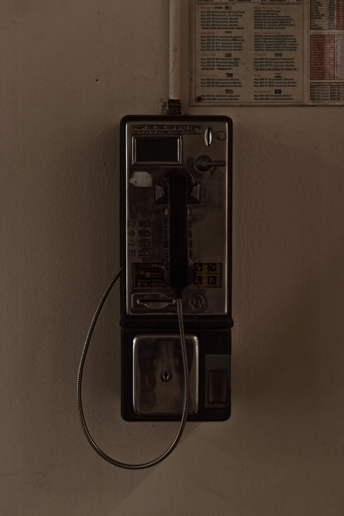 black and silver telephone on white painted wall