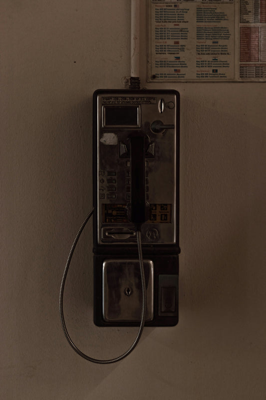 black and silver telephone on white painted wall