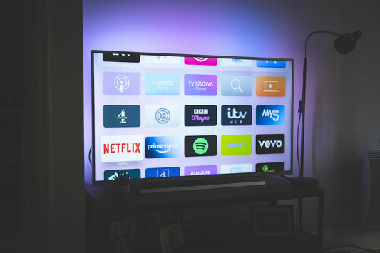 A television screen displaying a grid of streaming service app icons in a dim room